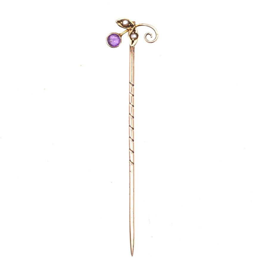 Edwardian 9ct gold tie pin with amethyst and seed pearl flower design, includes stoppers for secure fastening.