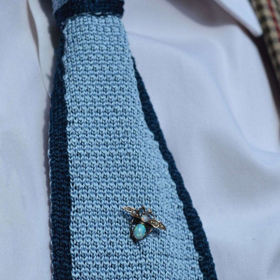 Edwardian 9ct gold bee tie pin with opal and seed pearl on a knitted blue tie.