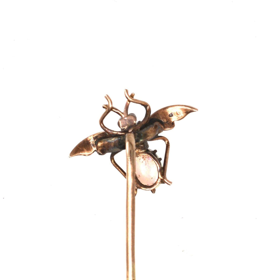 Edwardian 9ct gold bee tie pin featuring opal, seed pearl, and garnet eyes, capturing elegance and charm.