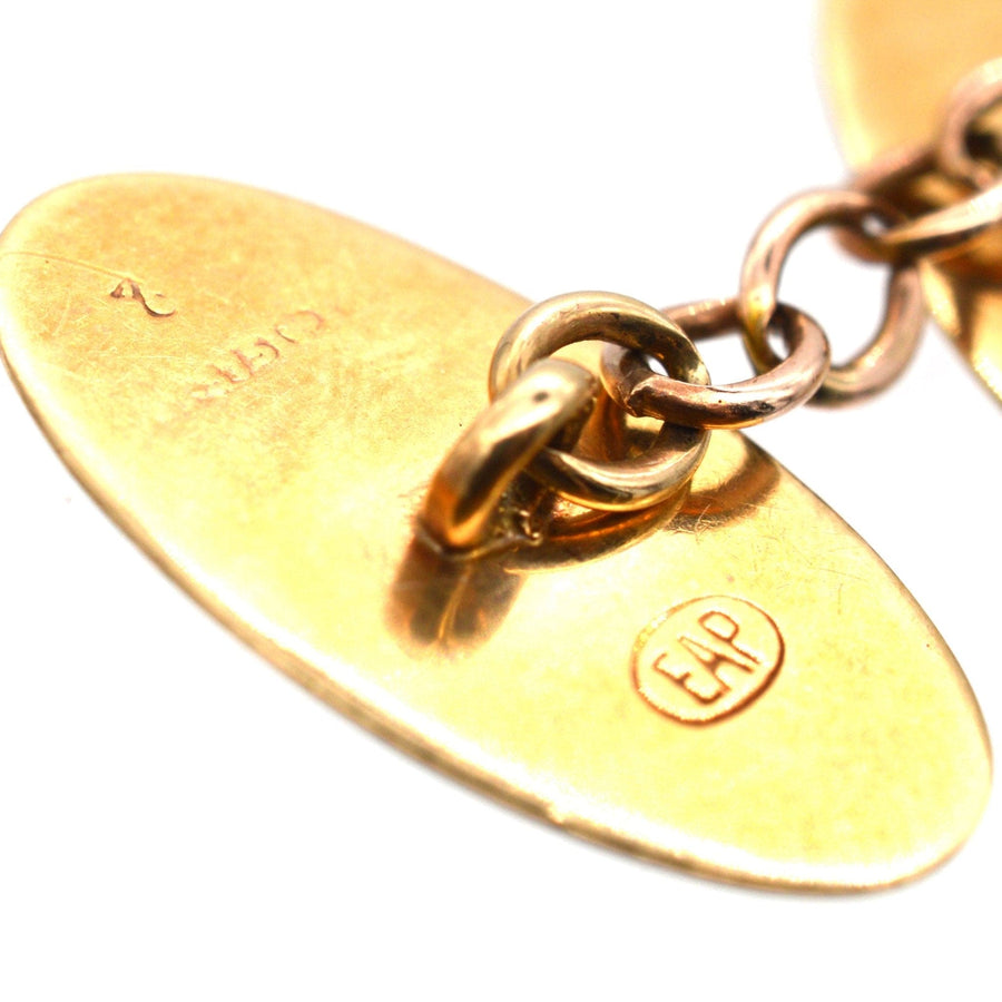Close-up of Edwardian 9ct gold cufflinks showcasing foliage design and hallmark detail, elegant vintage jewelry.