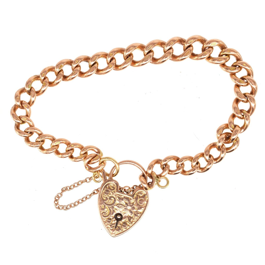 Edwardian 9ct gold curb link bracelet featuring a heart-shaped engraved padlock, weight 25.81g, elegant vintage charm.