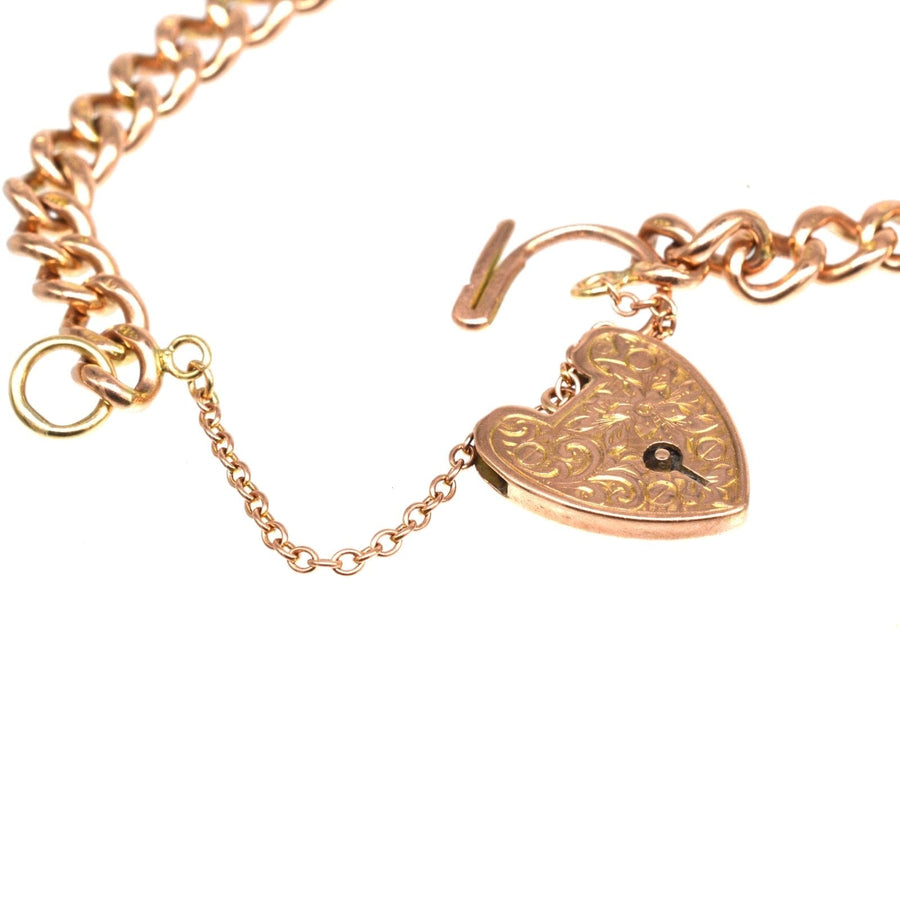 Close-up of Edwardian 9ct gold curb link bracelet featuring an ornate heart padlock clasp.