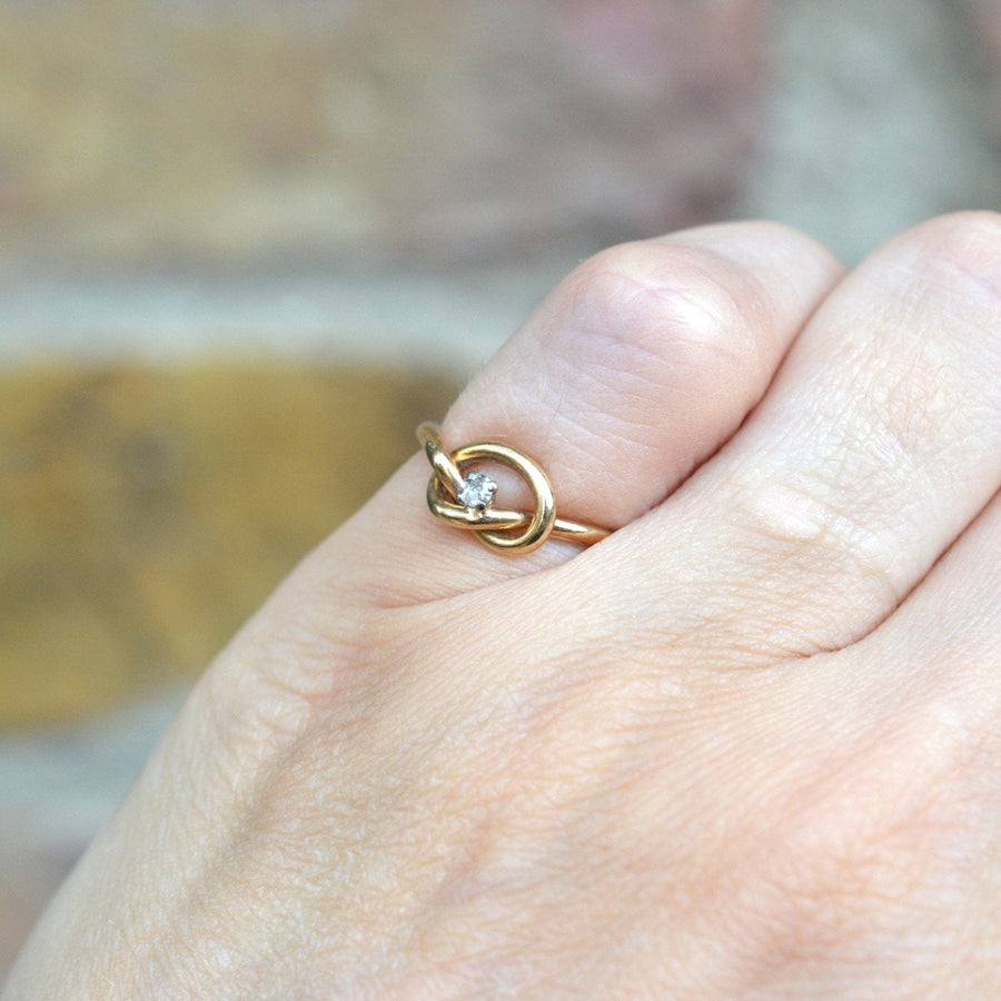 Elegant 9ct gold lovers' knot ring with diamond, symbolizing infinite love and connection.