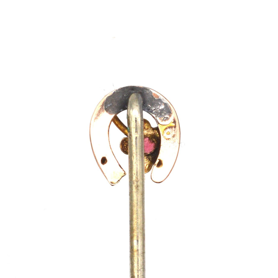 9ct gold horseshoe tie pin with intricate design and garnet accent, symbolizing luck and protection.