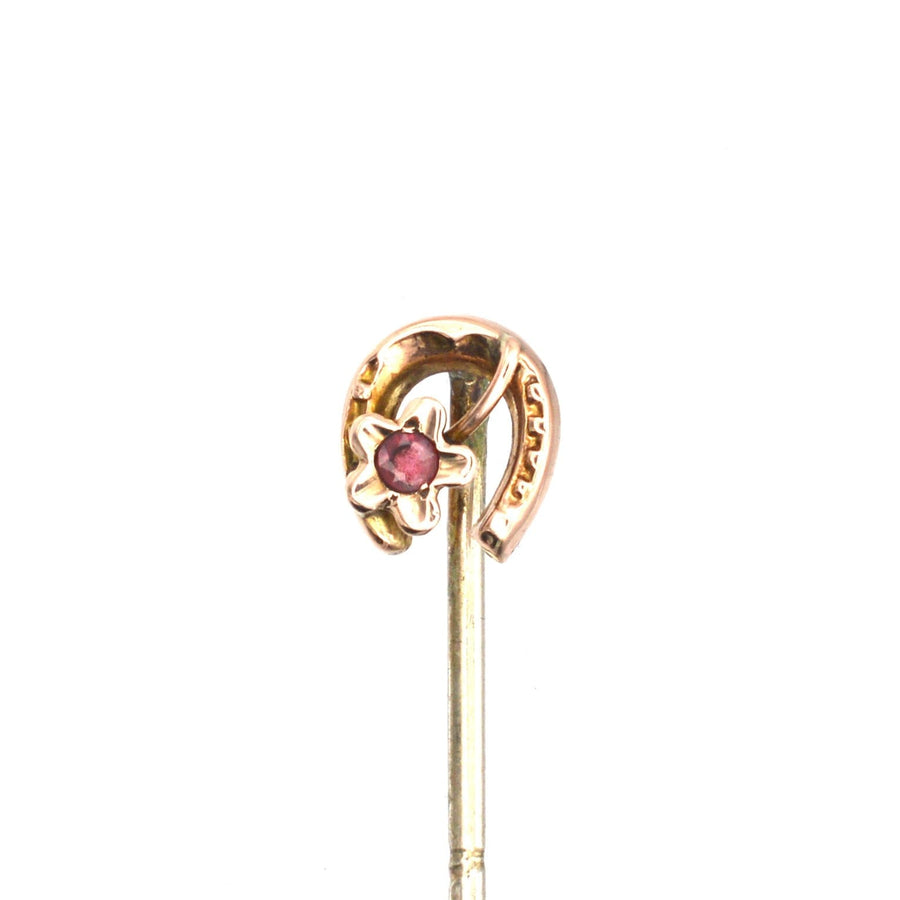9ct gold horseshoe tie pin with garnet accent, symbolizing luck and protection from evil.