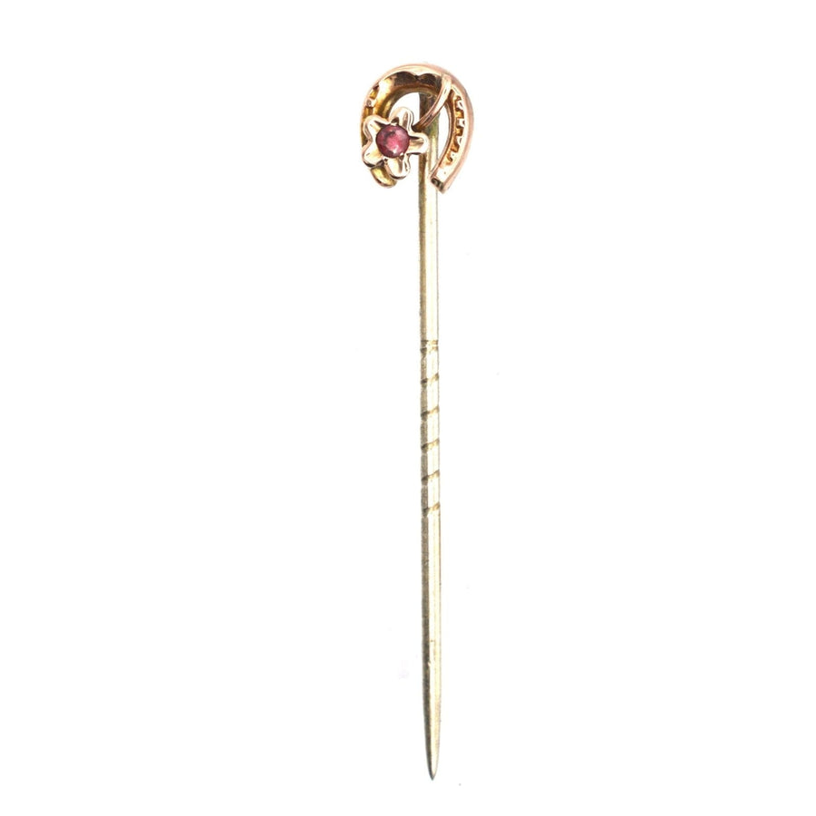 9ct gold horseshoe tie pin with garnet, symbolizing luck and protection, dating back to the Edwardian era.