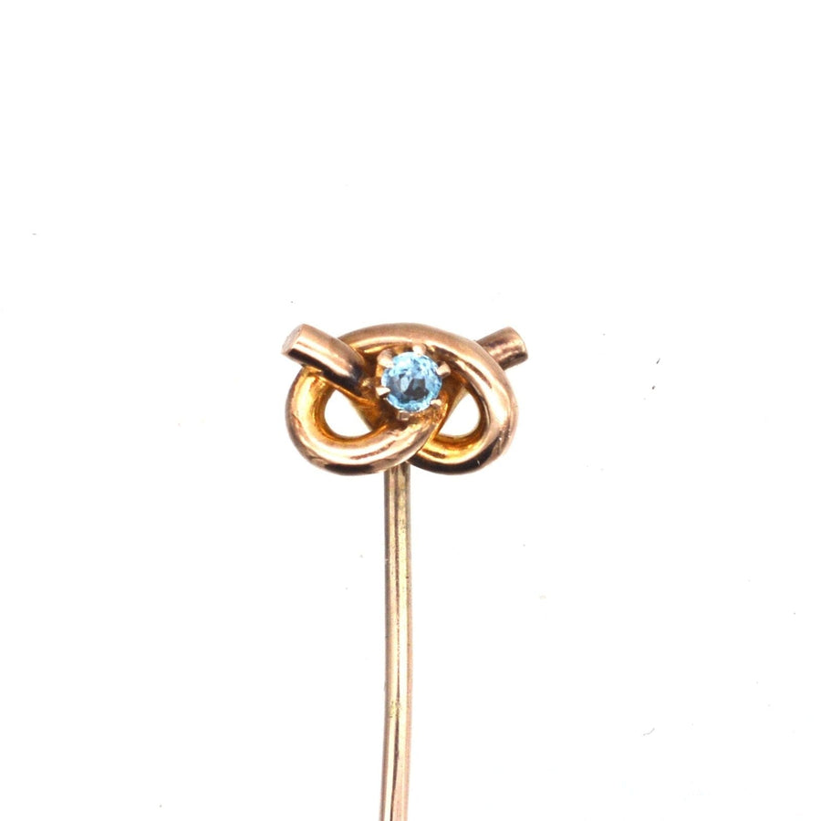 Edwardian 9ct gold lover's knot tie pin with aquamarine gemstone accent.