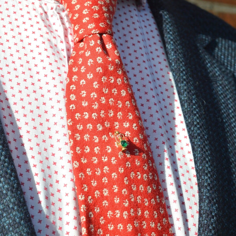 Edwardian gold railway signal lamp tie pin on red patterned tie, featuring a green light detail.