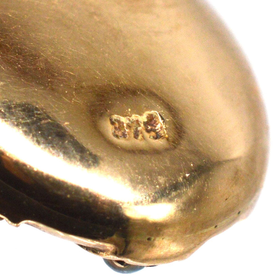 Close-up of the hallmark on an Edwardian 9ct gold pendant demonstrating quality and authenticity.