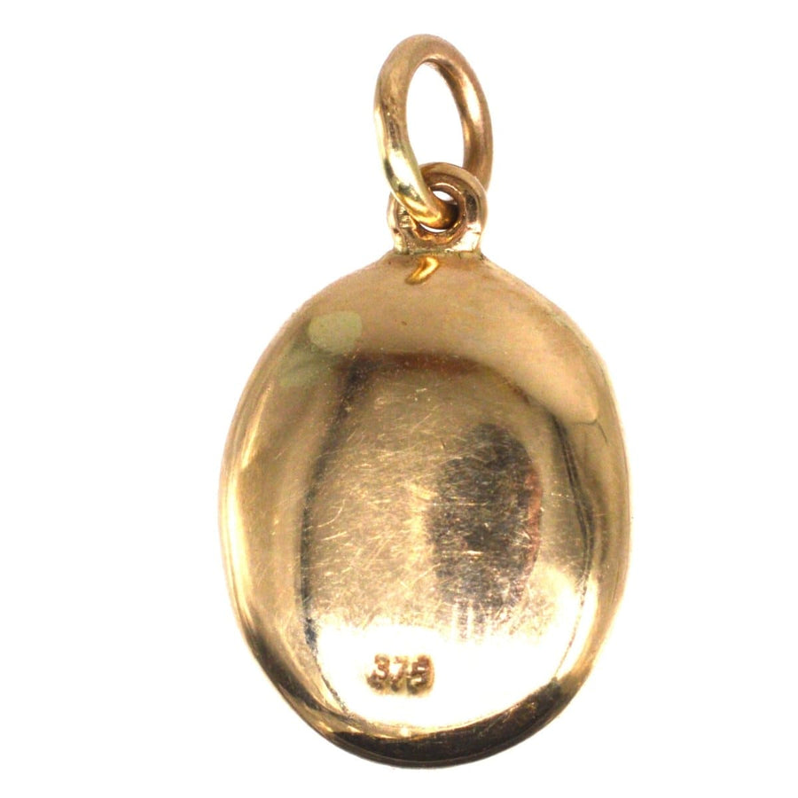 Back view of an Edwardian 9ct gold opal pendant showcasing its smooth, polished finish and hoop for hanging.
