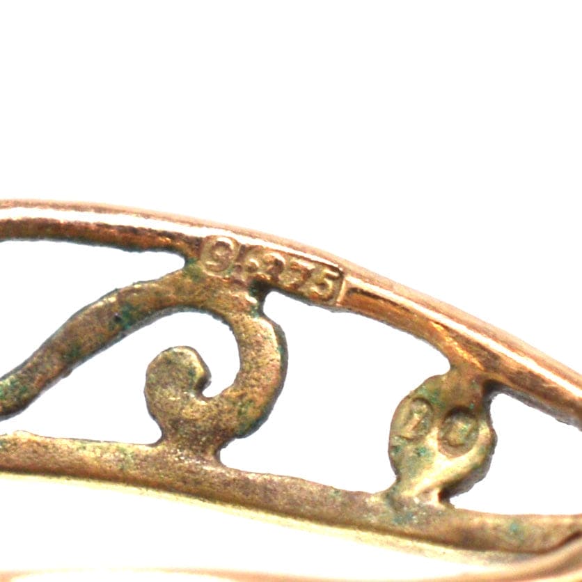 Close-up of a vintage brooch showing the 925 hallmark indicating its silver content.
