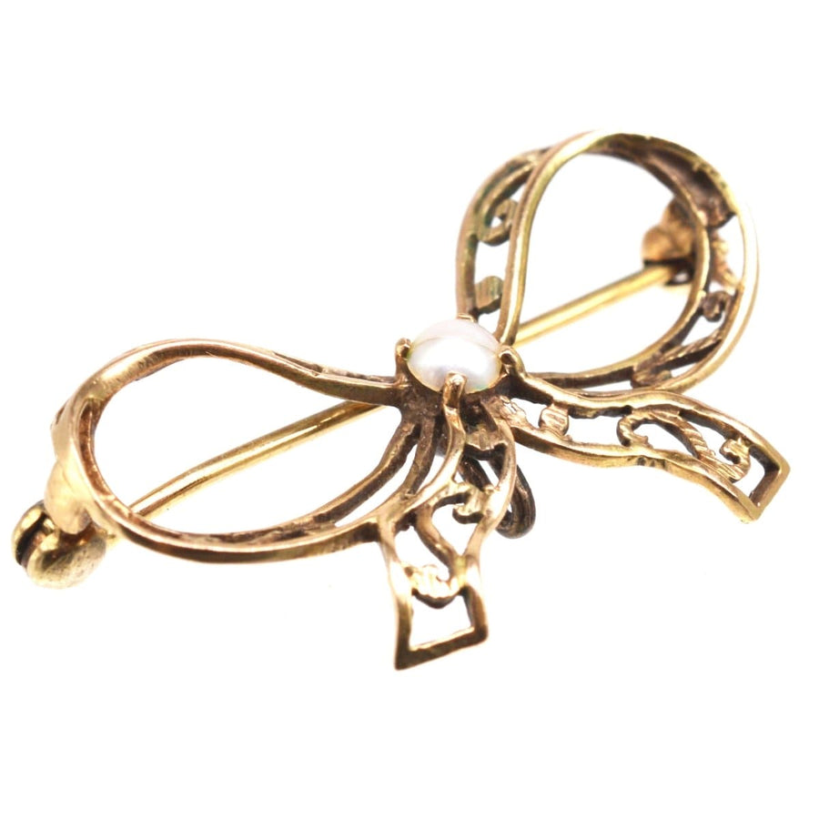 Edwardian 9ct gold bow brooch with pearl detail, perfect for lapels and versatile use.