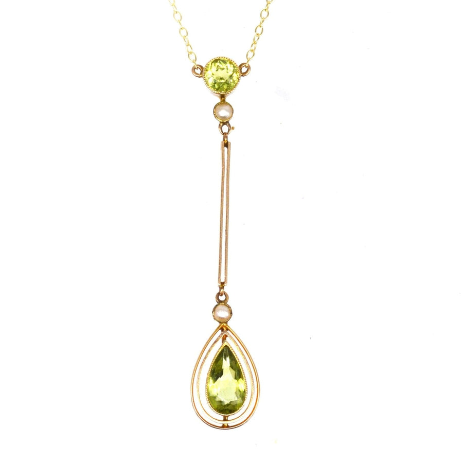 Edwardian 9ct gold pendant featuring peridot and pearl drop, showcasing its olive green brilliance.