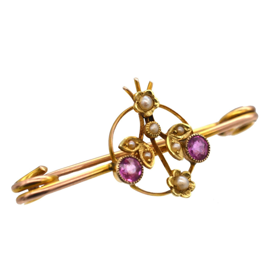 Edwardian 9ct gold brooch featuring pink sapphire flowers and natural split pearl accents.