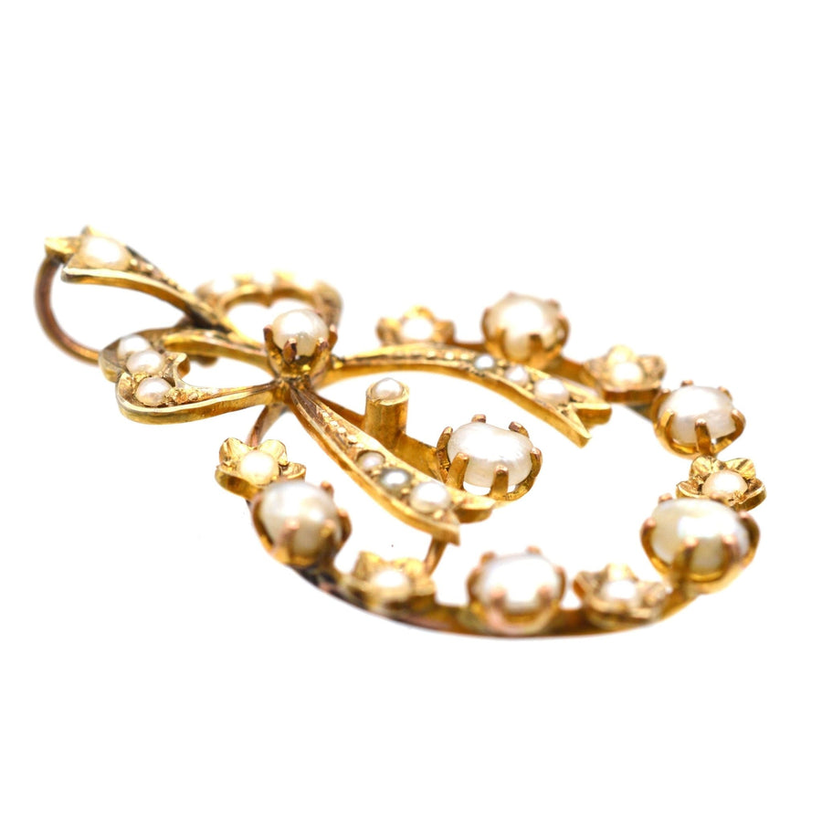 Edwardian 9ct gold pendant with split pearls and bow motif, inspired by 18th century designs.
