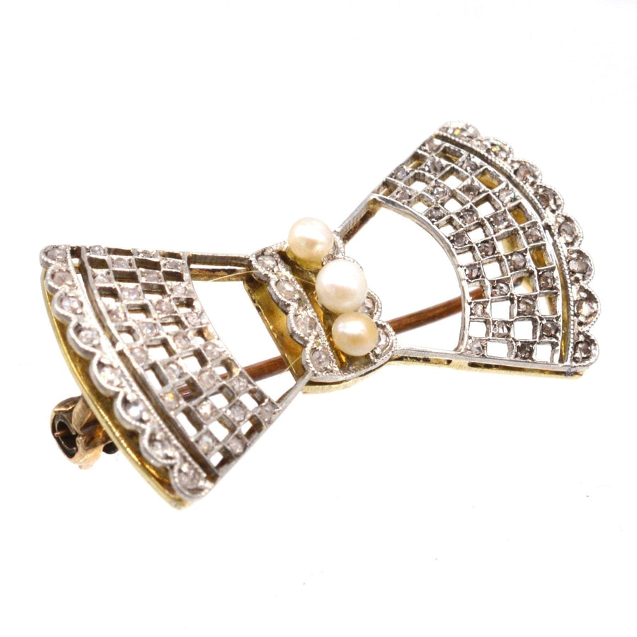 Edwardian lace bow brooch in 18ct gold and platinum with diamonds and pearls, showcasing intricate design and elegance.