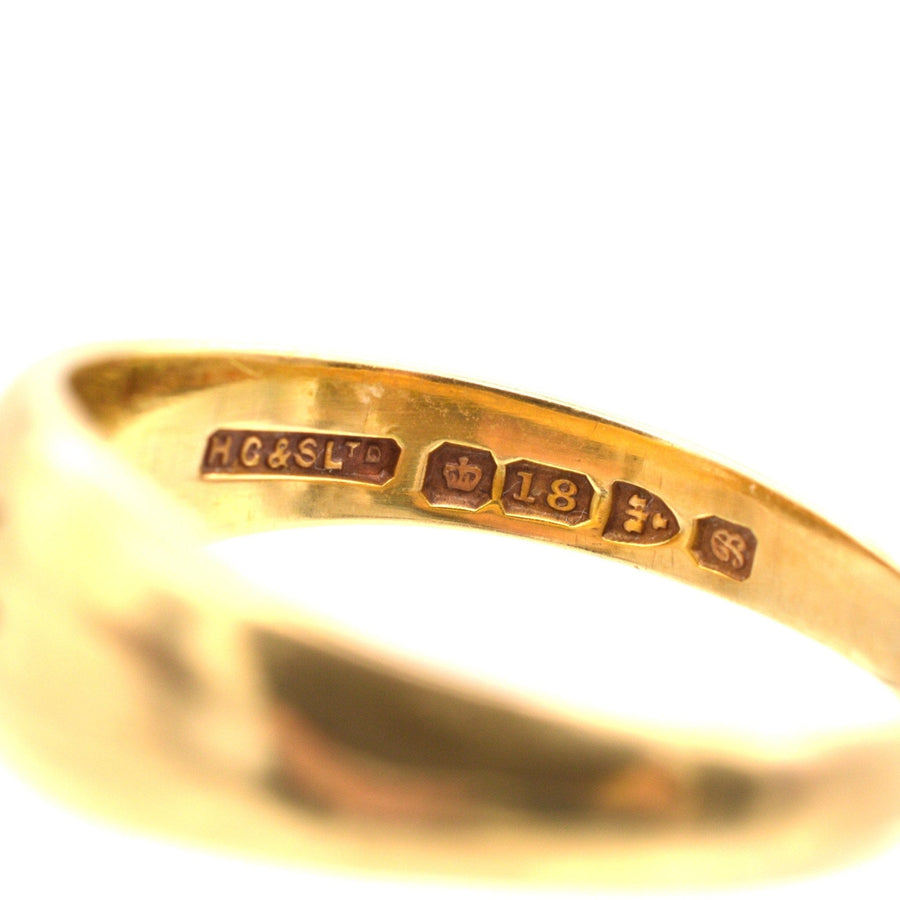 Close-up of hallmarks on Edwardian 18ct gold gypsy ring, showcasing authenticity and craftsmanship.