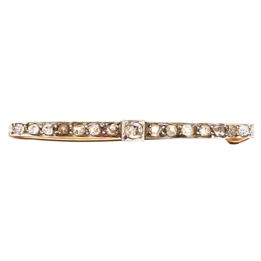 Edwardian platinum and 15ct gold bar brooch featuring old mine cut diamonds, perfect for dresses and ties.