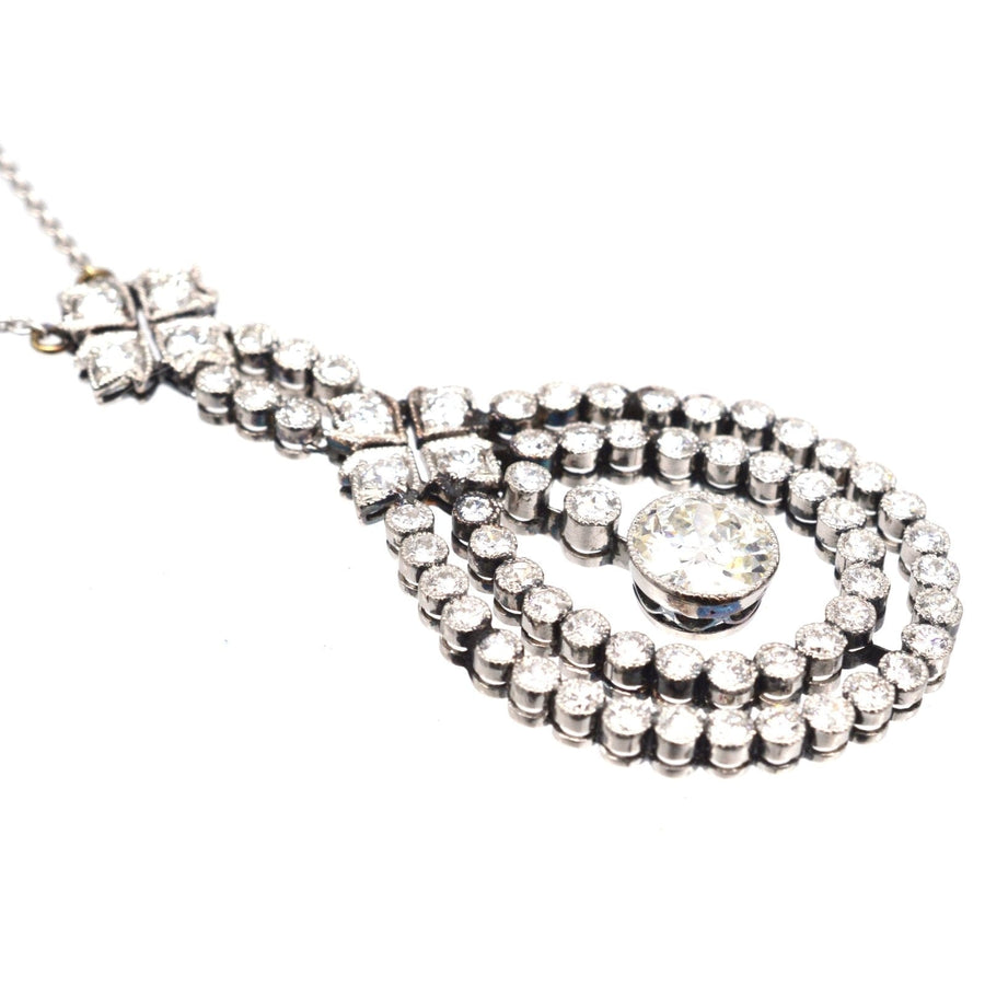 Edwardian platinum pendant with 1.3 carat diamond and smaller diamonds, suspended on a white gold chain.