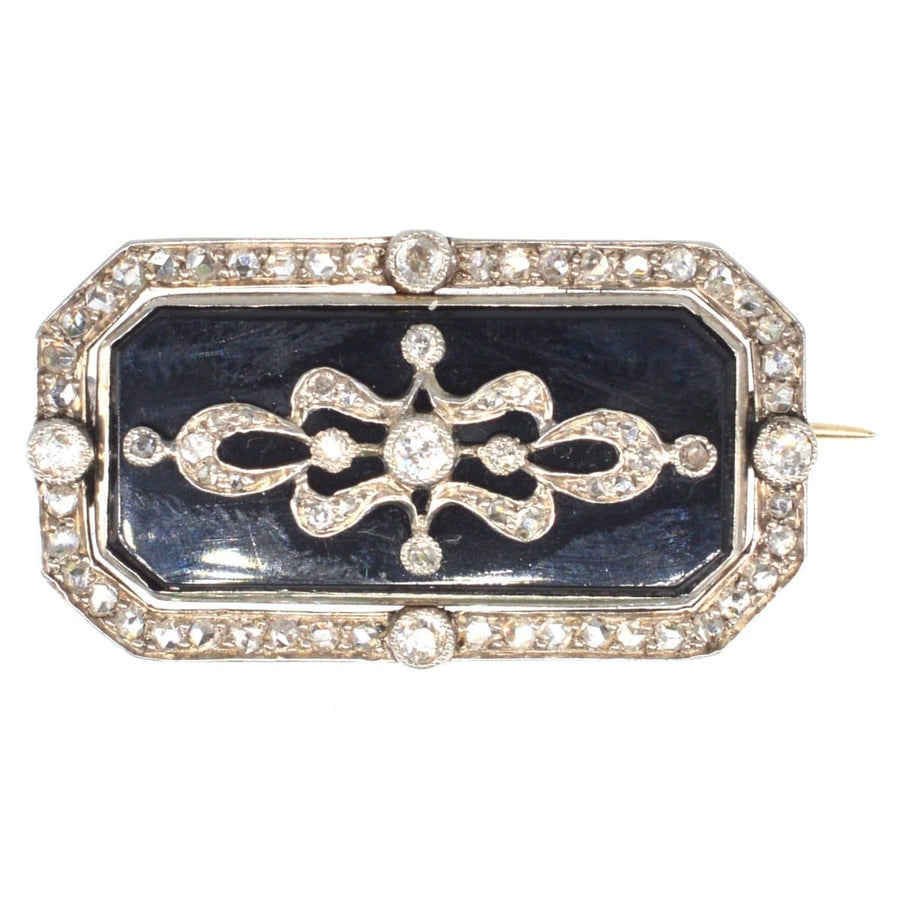 Edwardian brooch in platinum and gold featuring onyx with diamond embellishments, designed by Parkes.