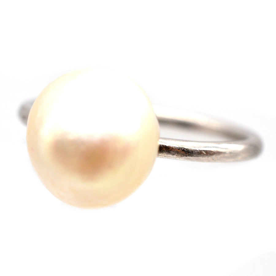 Edwardian platinum solitaire ring featuring a natural saltwater pearl, circa 1910s, with a lustrous finish.