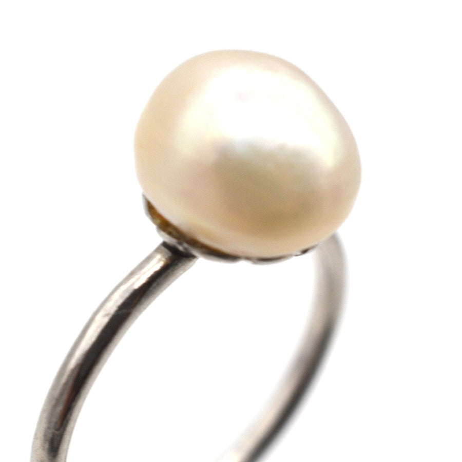 Edwardian platinum ring featuring a natural saltwater pearl, circa 1910, with a simple and elegant design.