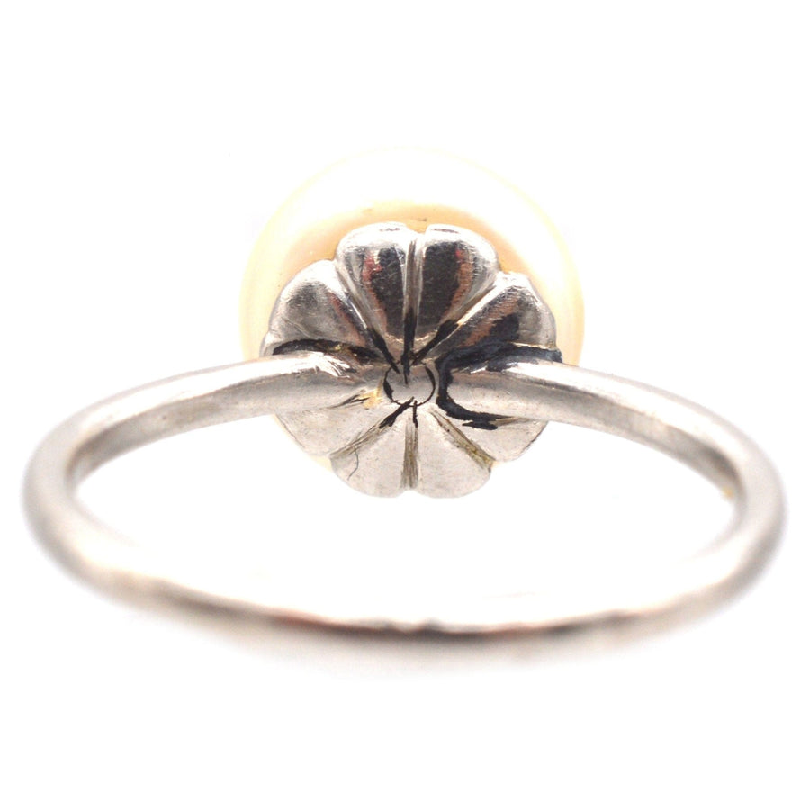 Edwardian platinum solitaire ring featuring a natural saltwater pearl, showcasing intricate floral design.