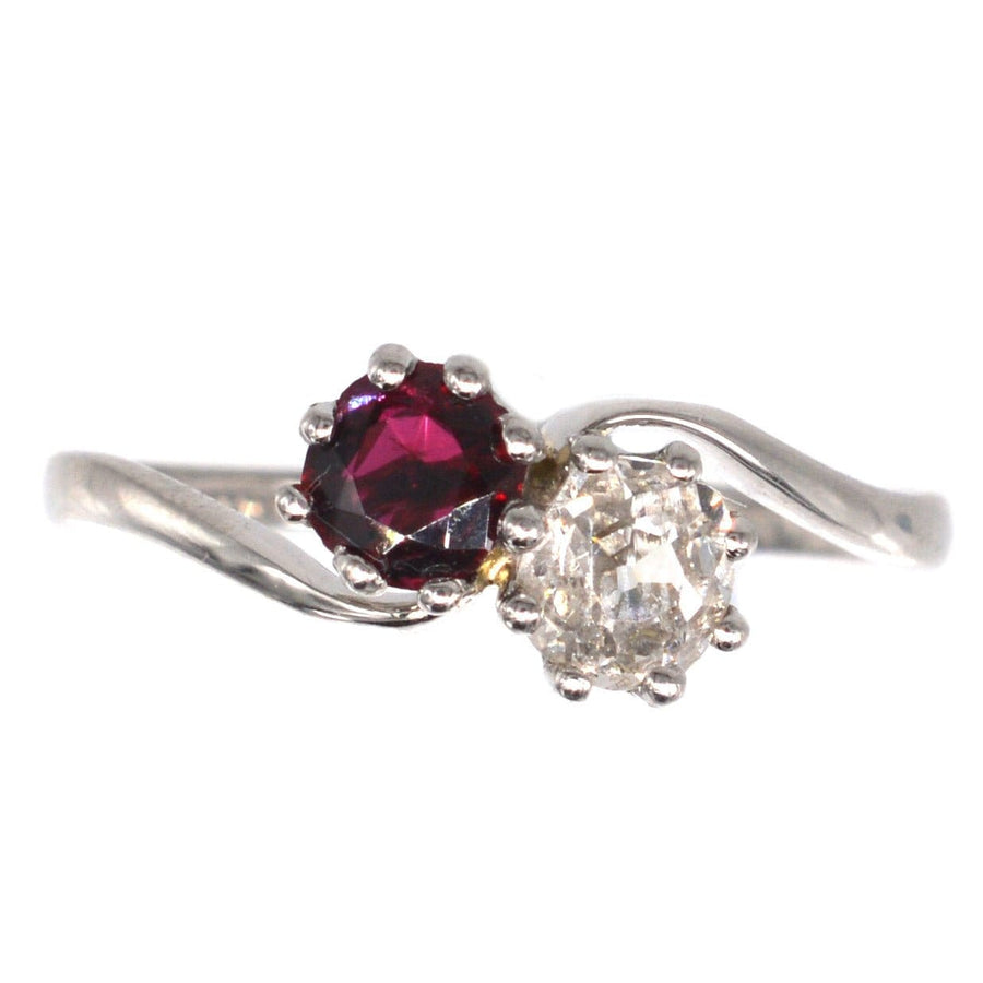 Edwardian platinum crossover ring featuring a ruby and old mine cut diamond, symbolic of love.