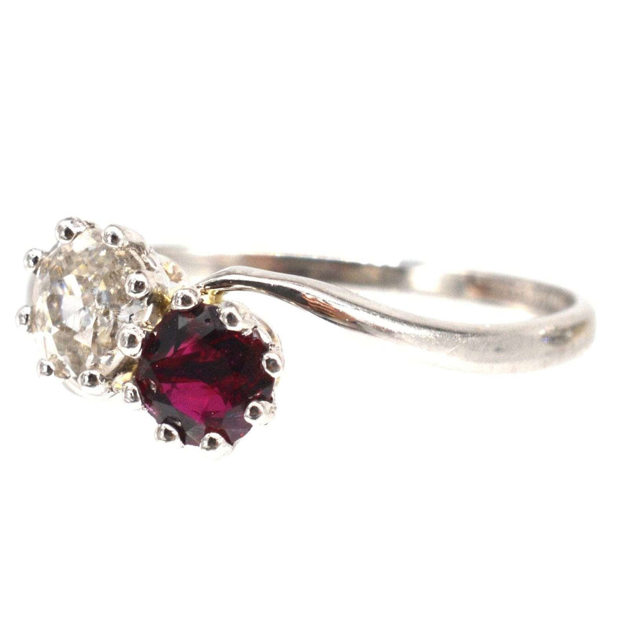 Edwardian platinum crossover ring featuring a ruby and old mine cut diamond, symbolizing love.