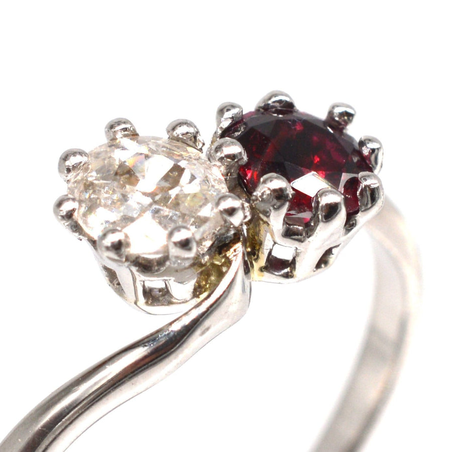 Edwardian platinum crossover ring featuring a ruby and old mine cut diamond, symbolizing love.