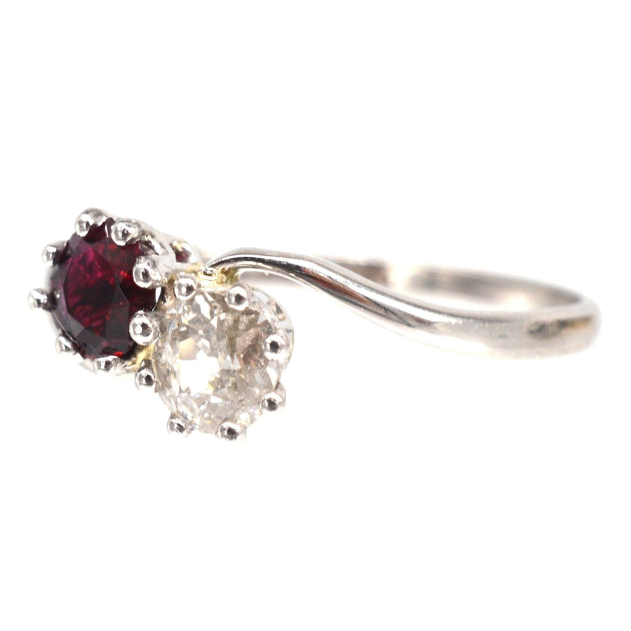 Edwardian platinum crossover ring featuring a vibrant ruby and an old mine cut diamond, perfect for engagement or anniversary.
