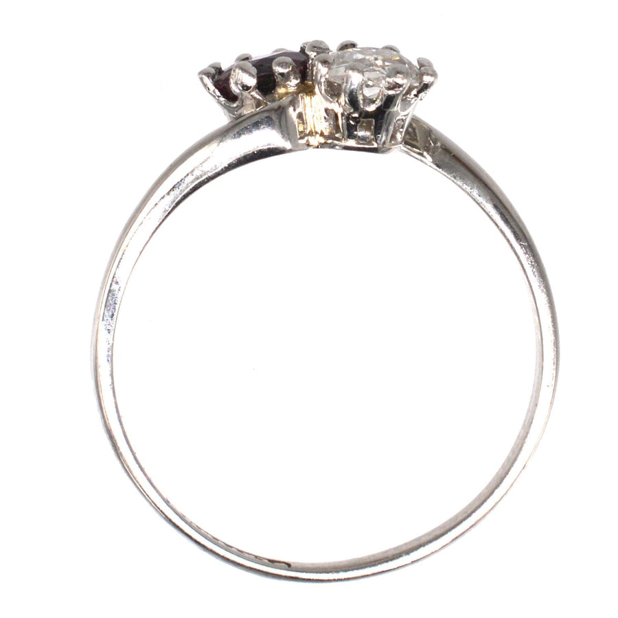 Edwardian platinum crossover ring featuring a ruby and old mine cut diamond in a romantic 'Toi et Moi' design.