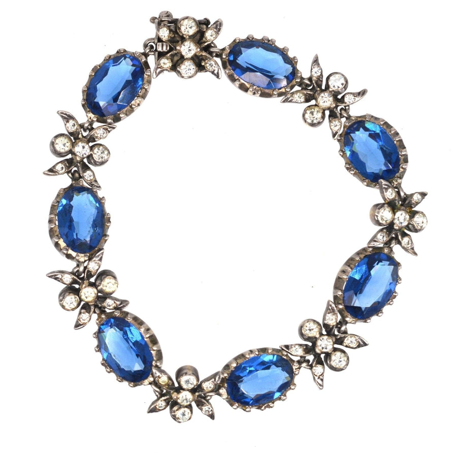 Edwardian silver bracelet with sapphire blue and white paste stones, featuring floral designs.