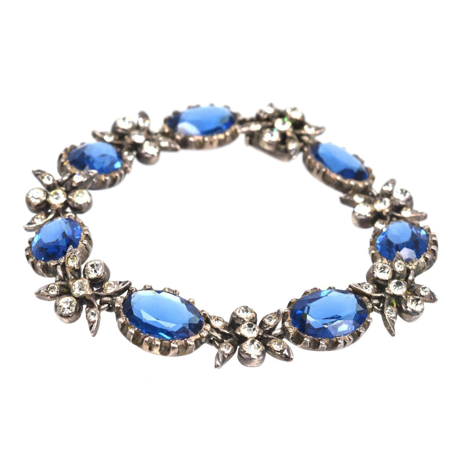 Edwardian silver bracelet featuring sapphire blue and white paste stones, beautifully designed with floral accents.