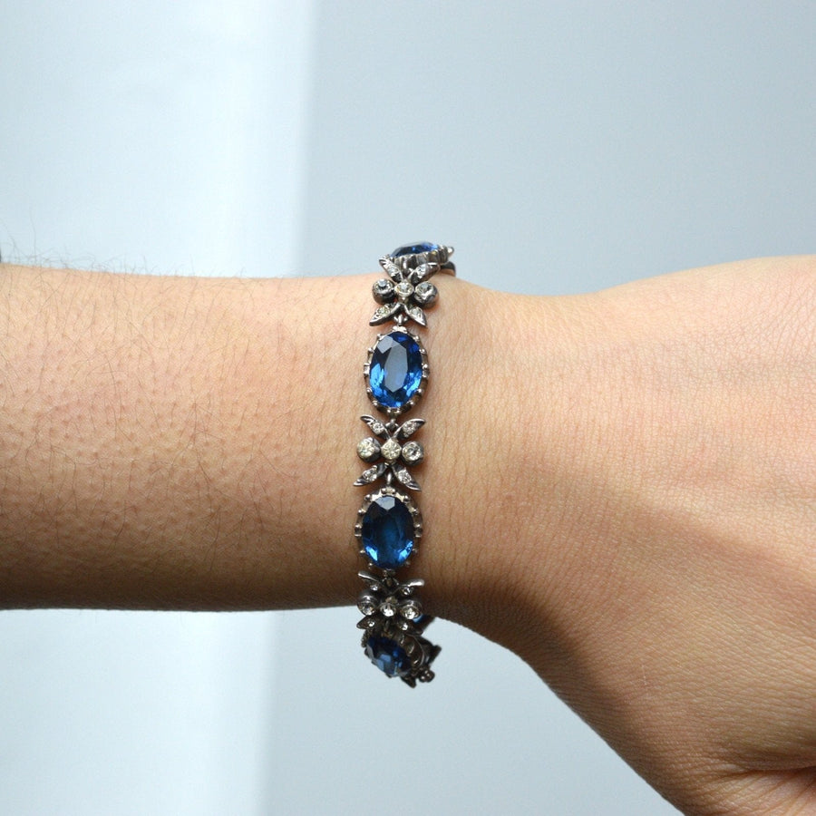 Edwardian silver bracelet featuring sapphire blue paste and white accents, worn on a wrist, showcasing its elegant design.