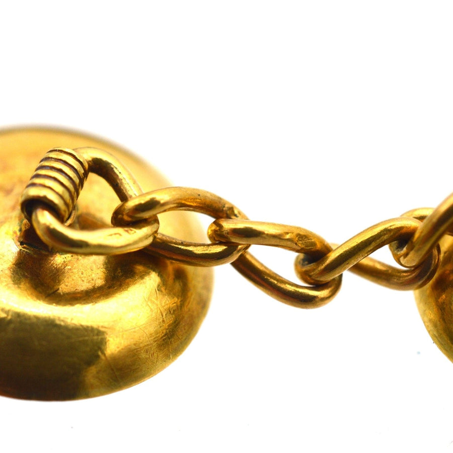 Close-up of French 18ct gold cufflinks showcasing intricate design and linking chain detail.
