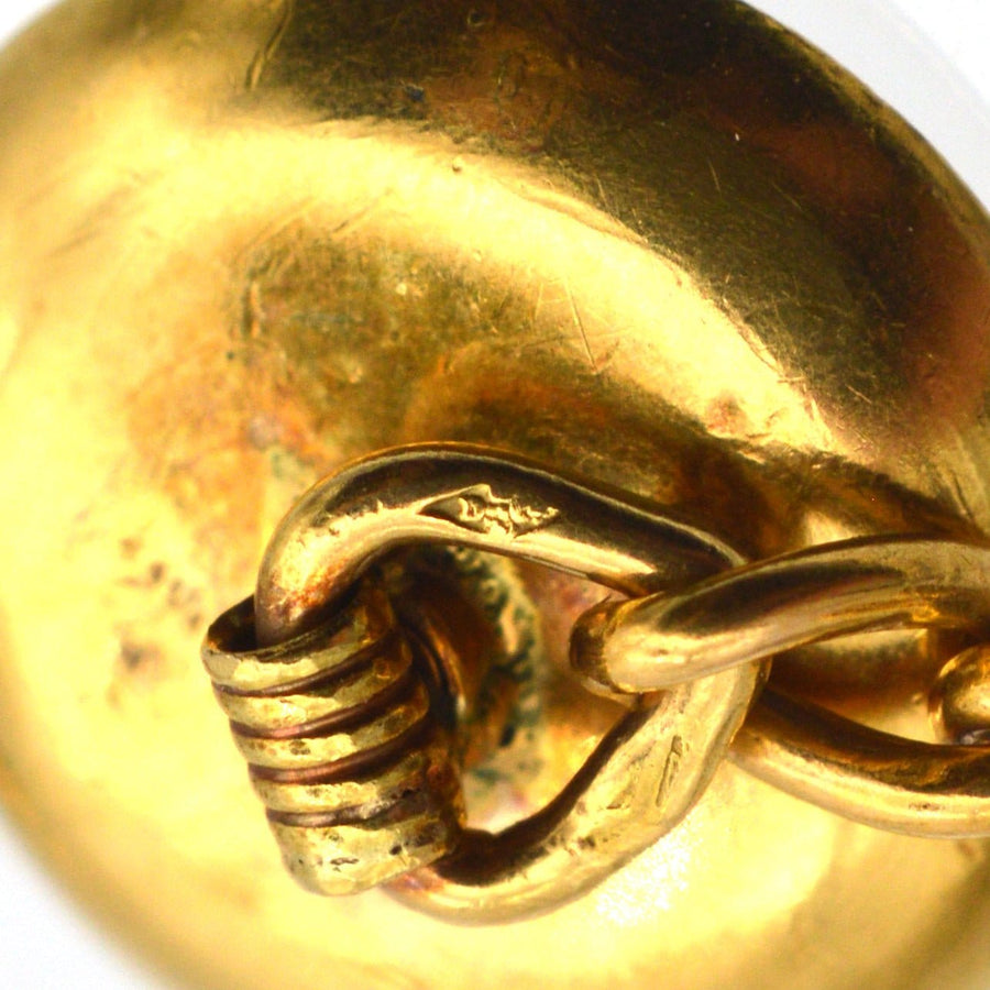 Close-up of a French 18ct gold cufflink, showcasing its gold finish and unique clasp detail.