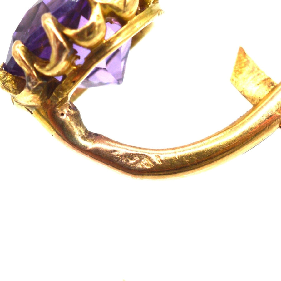 Close-up of 19th century gold earrings showcasing amethyst and pearl details, emphasizing craftsmanship.