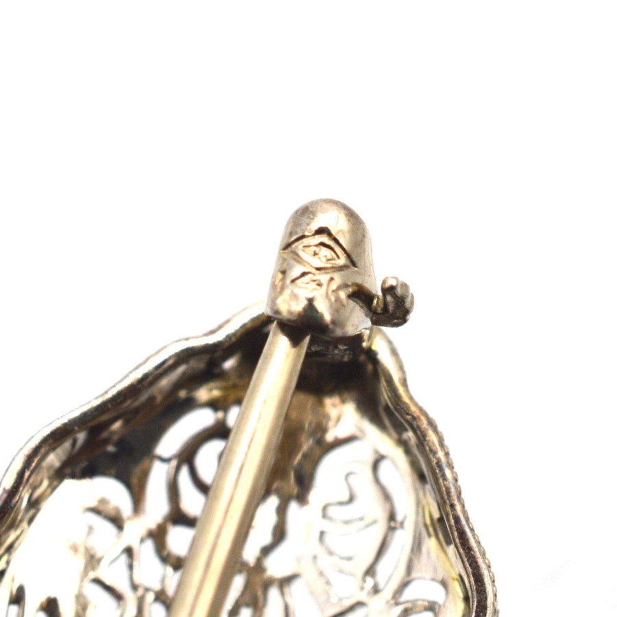 Close-up of the intricate design of a French Art Deco 14ct gold brooch showcasing delicate white gold tracery.