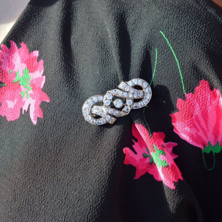 French Art Deco silver paste brooch with geometric design on a floral scarf.