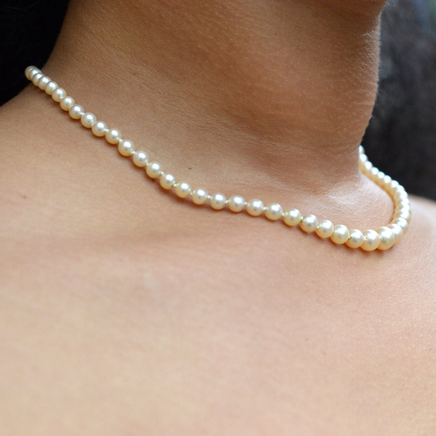 Elegant cultured pearl necklace worn, showcasing its classic and timeless beauty against the skin.