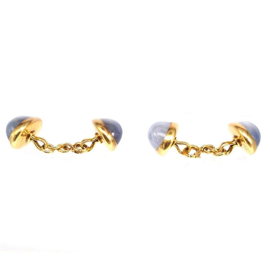 Elegant 18ct gold star sapphire cufflinks featuring grey-blue cabochons with unique asterism effect.