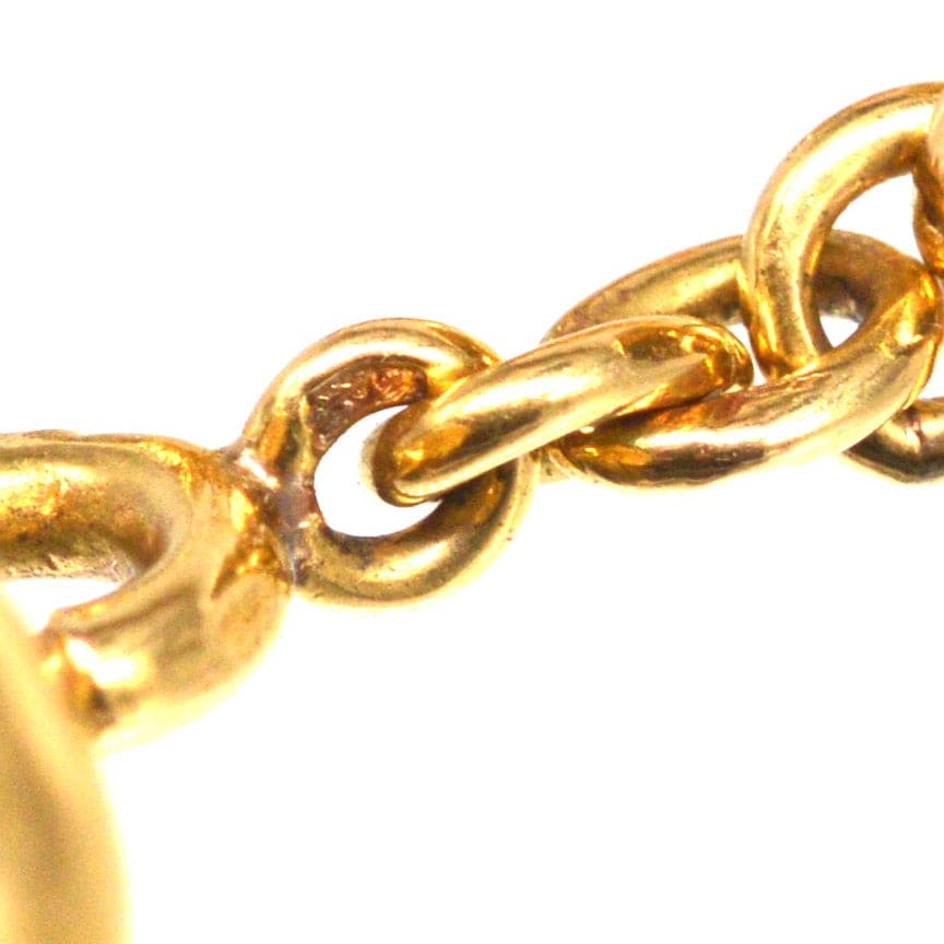 Close-up of a vintage gold chain link, highlighting its intricate design and luster.