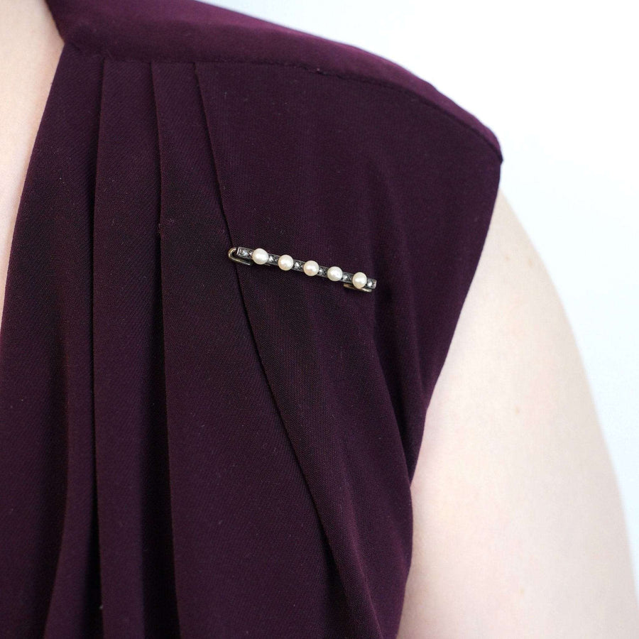French 19th-century gold and silver bar brooch with natural pearls and rose cut diamonds on a purple dress.