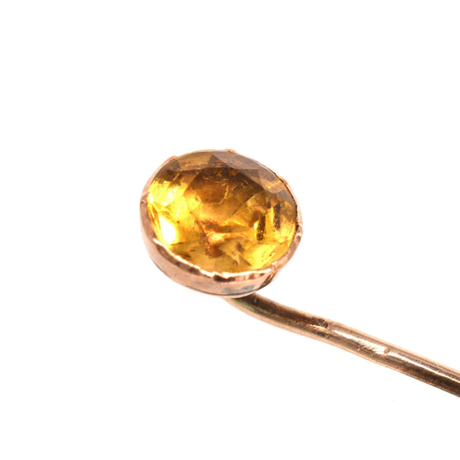 Close-up of a Georgian 9ct gold tie pin featuring a sparkling citrine gemstone.