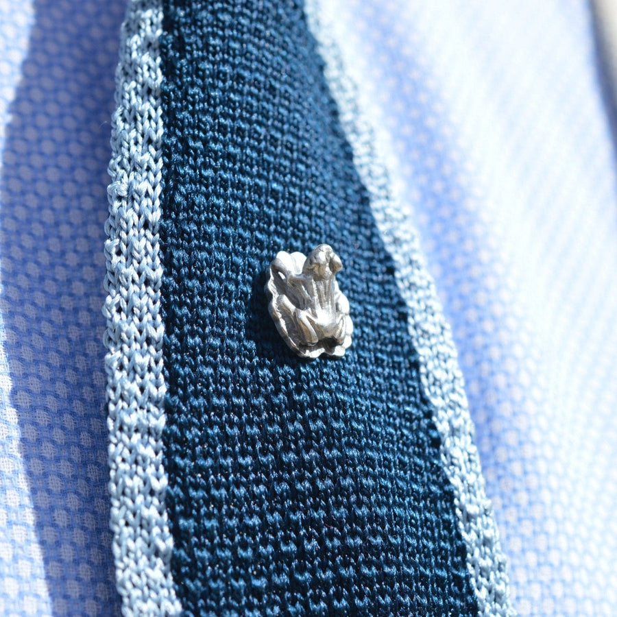 German 1940s silver frog tie pin on a knitted navy tie, adding a unique and stylish touch to formal attire.