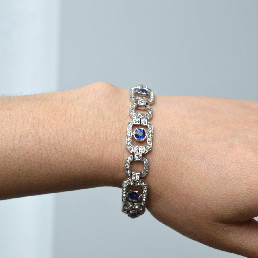 Art Deco silver bracelet by Knoll & Pregizer featuring blue 'sapphire' and white paste stones on a wrist.