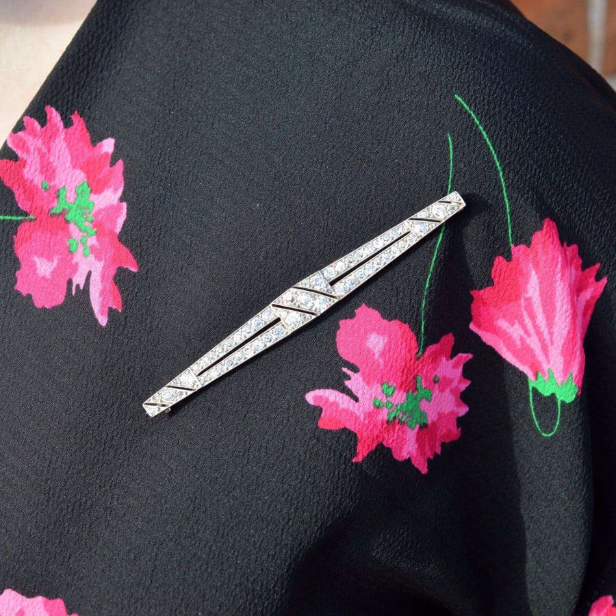 Large Art Deco platinum diamond bar brooch on a floral black blouse, showcasing its elegant design and sparkling diamonds.