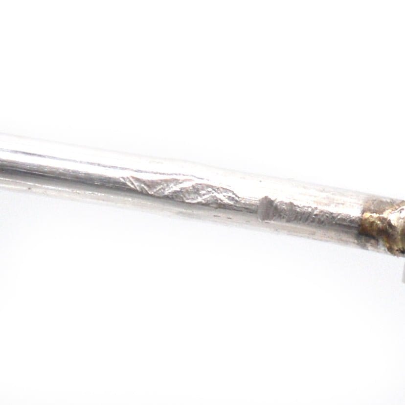Close-up of a silver brooch pin showing intricate details and texture, ideal for vintage jewelry enthusiasts.
