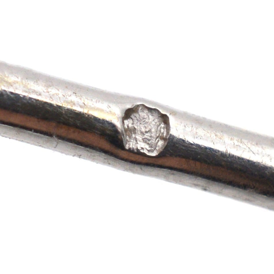 Close-up of a vintage silver brooch showing intricate metalwork detail and hallmark from the 1930s.